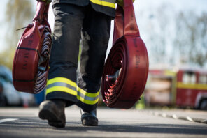 A Firefighter carrying hoses