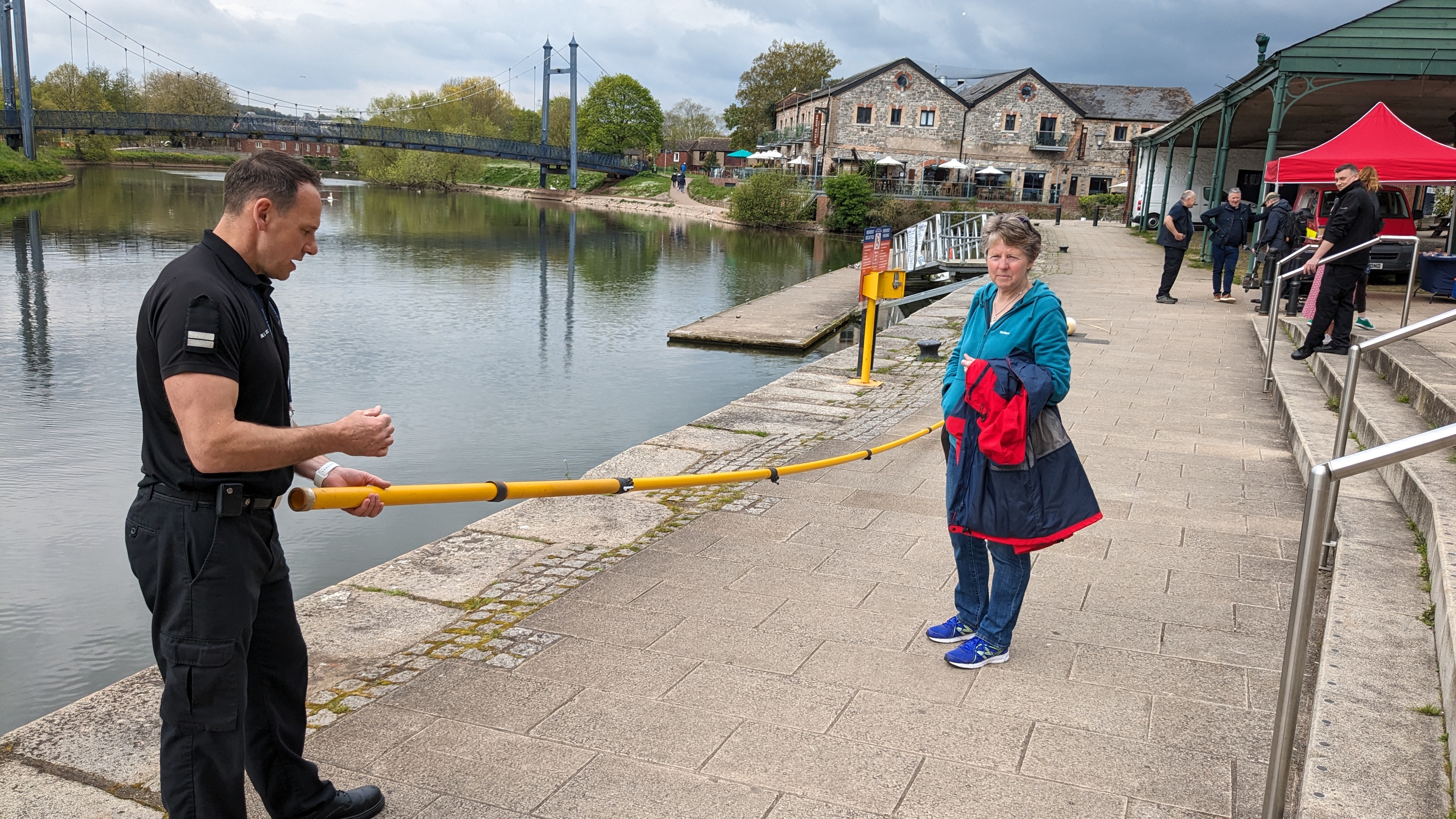 Steve Fisher from the Prevention team at Devon and Somerset Fire and Rescue Service demonstrates how to use life saving equipment to a member of the public on the quayside on Exeter Quay