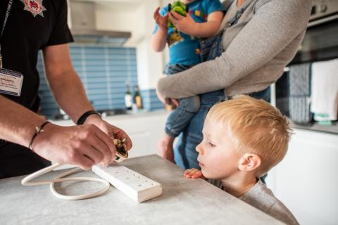 Our home safety technician educating toddler about electrical safety