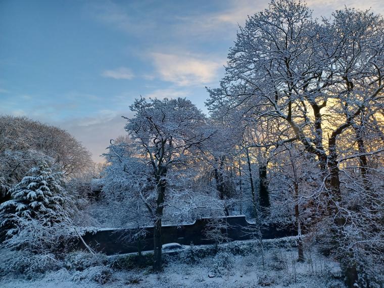 A snowy scene with a car driving uphill