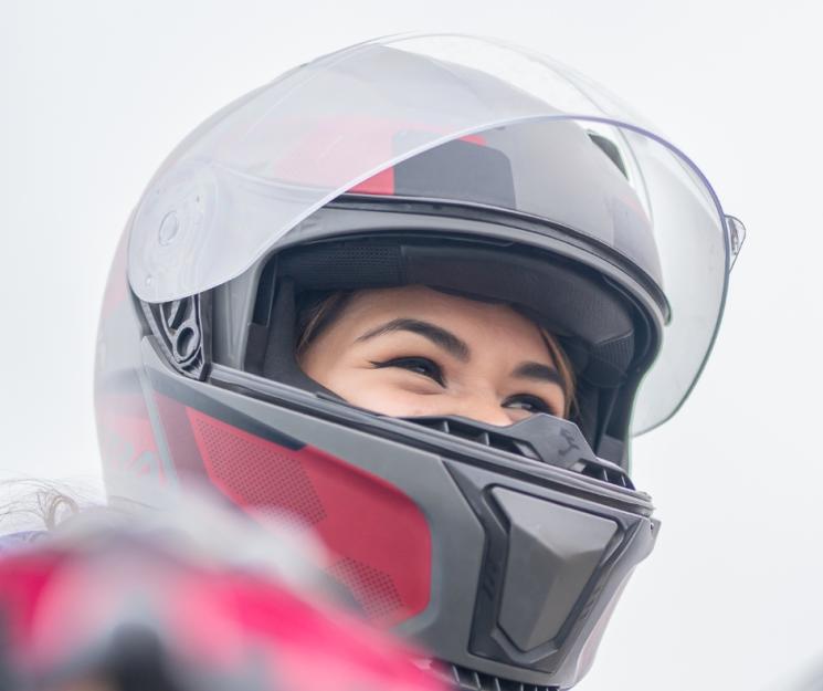 An image of someone looking into the distance with a motorcycle helmet on. 